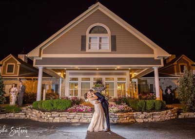 The newlyweds kiss in front of their Indianapolis wedding reception venue, The Ballroom at The Willows