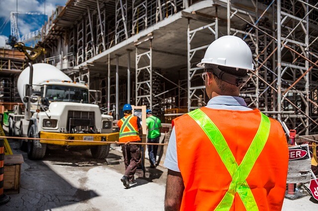Image of a construction site with a construction manager overseeing site
