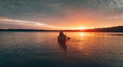 beautiful-distant-shot-woman-riding-kayak-middle-lake-during-sunset