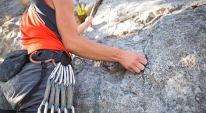 climber-red-t-shirt-climbs-gray-rock-strong-hand-grabs-lead