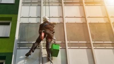 industrial-mountaineering-worker-uniform-washing-exterior-glazing-residential-facade-building