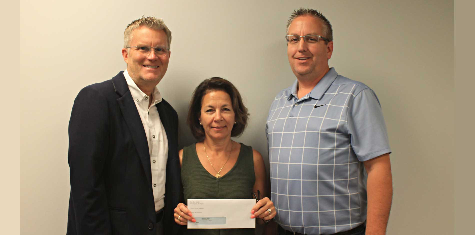 Bob Gray & J. Beatty with non-profit representative who is holding a donation check