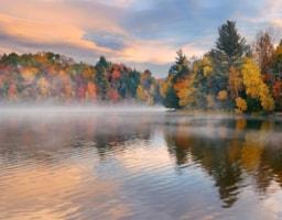 lake-fog-sunrise-with-autumn-foliage-mountains-new-england-stowe