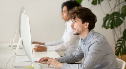 young-serious-employee-focused-computer-work-multiracial-office