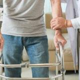 doctor helping male patient walk with walker (source: freepik.com)