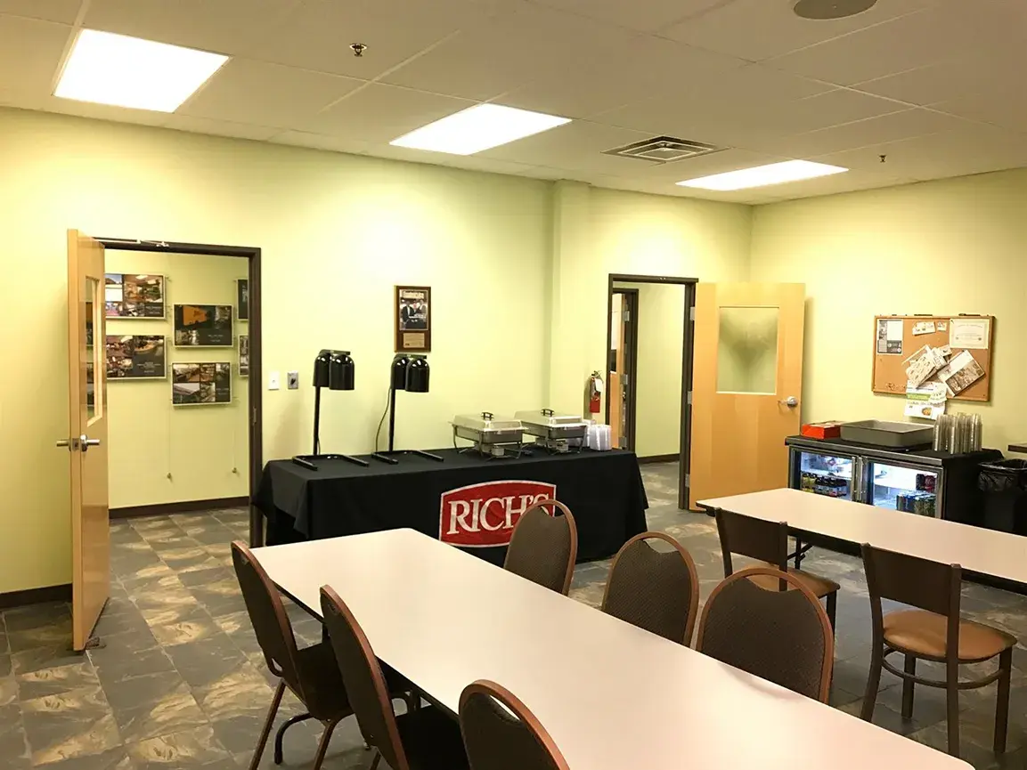 Training room with tables, chairs, heat lamps, and table with Rich's Food tablecloth